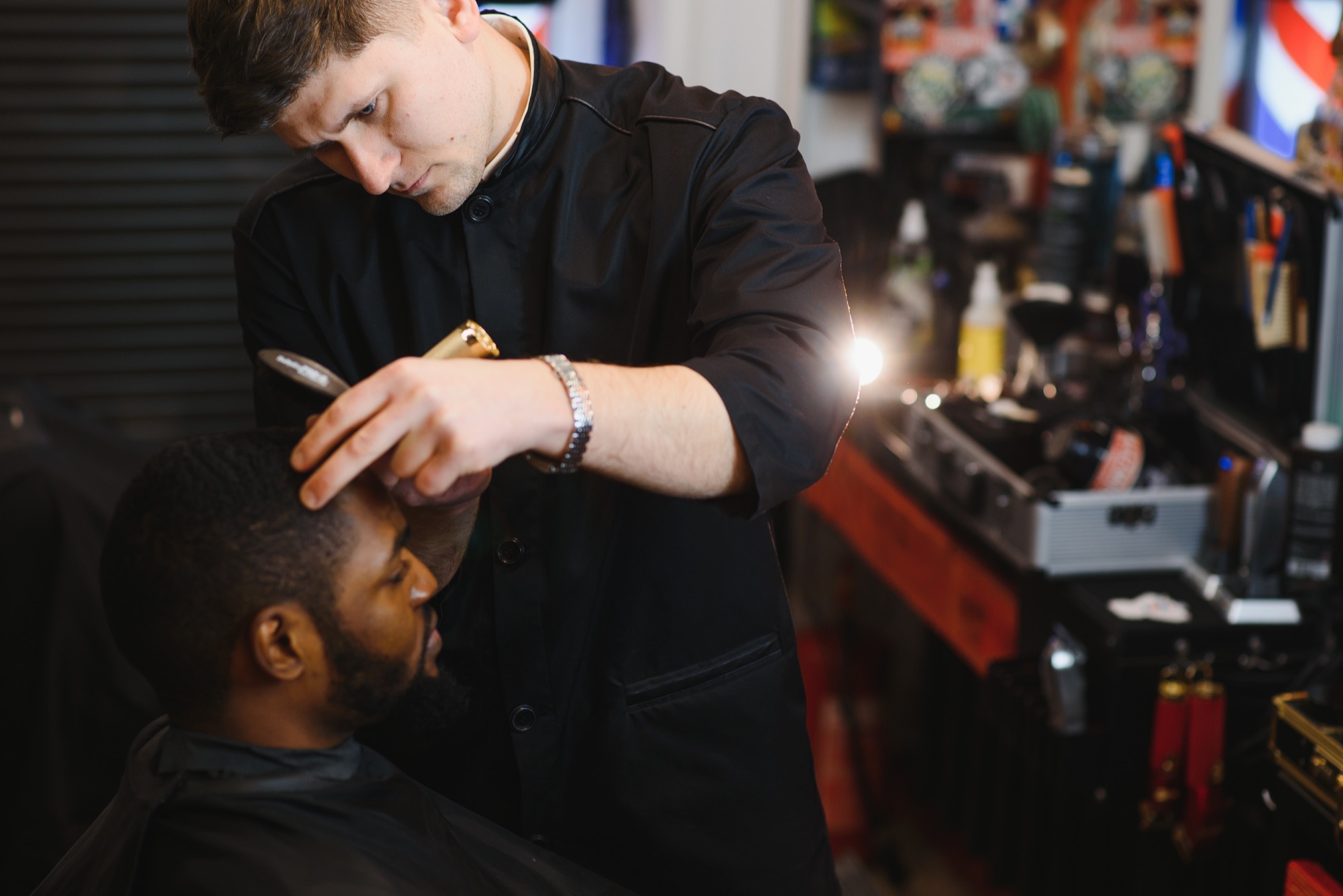 Lead barber giving a client a careful haircut.